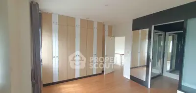 Spacious bedroom with modern wardrobe and wooden flooring