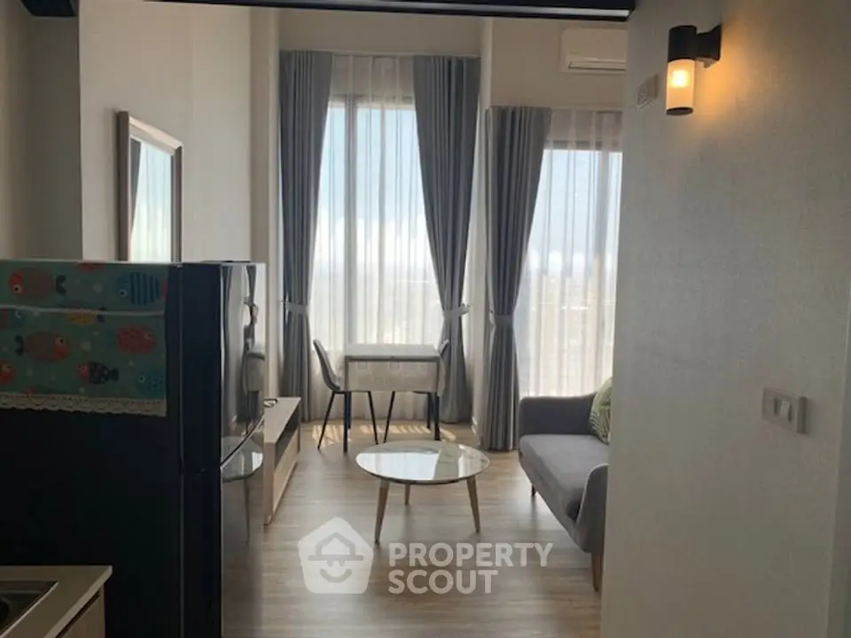 Modern living room with large windows and stylish decor in a high-rise apartment.