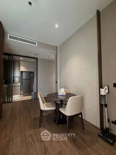 Modern dining area with sleek furniture and open kitchen layout in a stylish apartment.