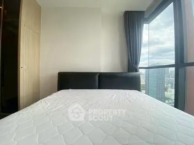 Modern bedroom with large window offering stunning city view
