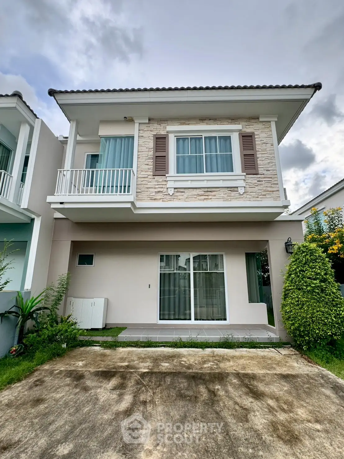 Modern two-story house with stone facade and small balcony
