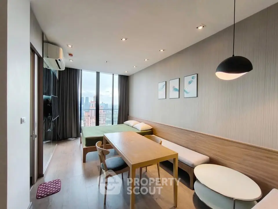 Modern studio apartment with city view, featuring sleek furniture and stylish decor.