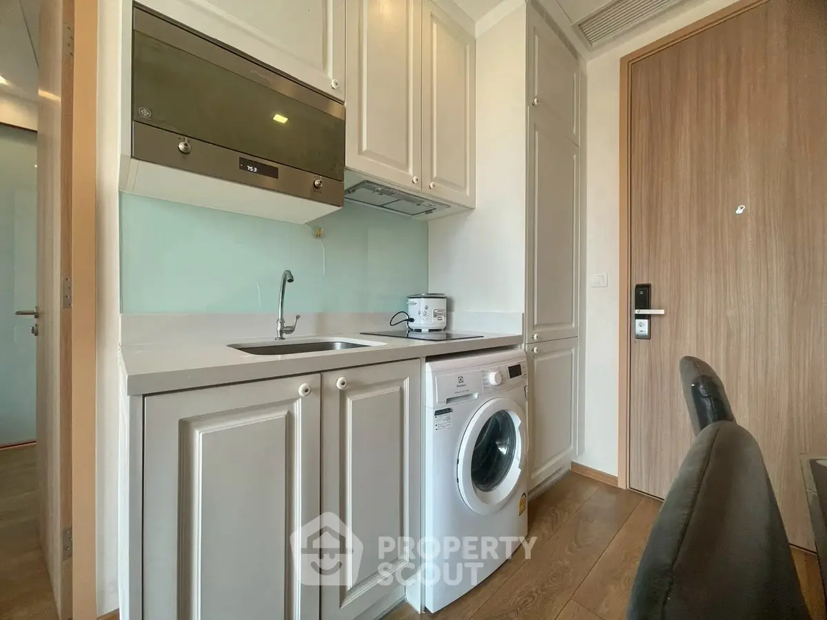 Modern compact kitchen with washing machine and sleek cabinetry