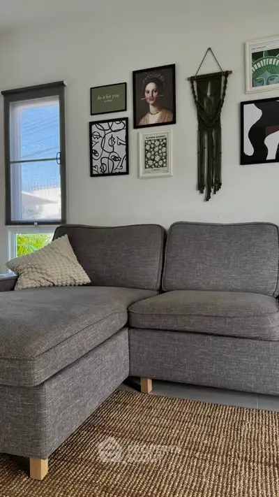 Stylish living room with gray sectional sofa and artistic wall decor