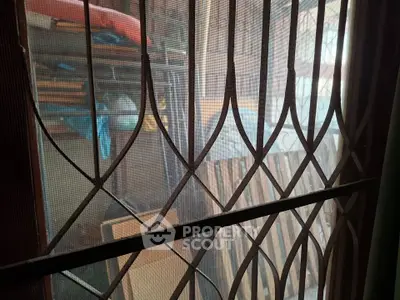 Secure storage area with metal grill and stacked items, ideal for organizing belongings.