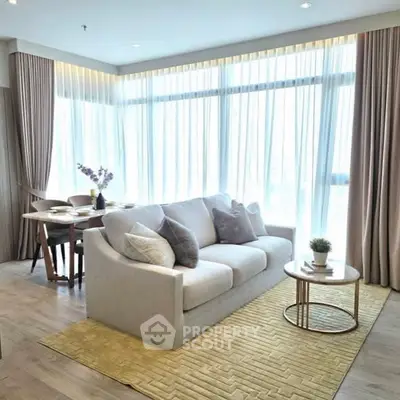 Elegant living room with large windows and cozy seating area