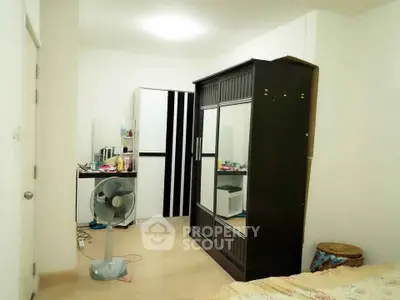 Cozy bedroom with wardrobe and fan, ideal for comfortable living.