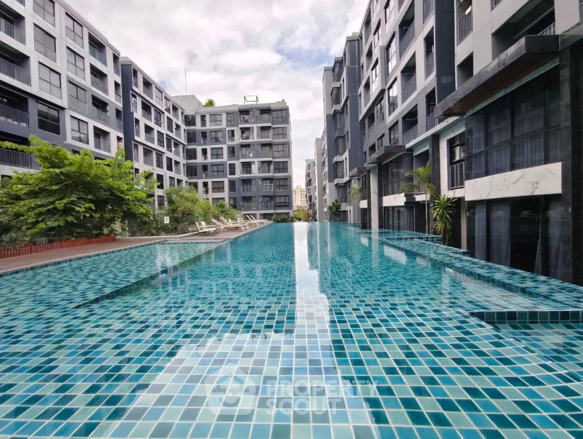 Luxurious modern apartment complex with stunning outdoor pool and lush greenery.