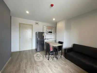 Modern apartment interior with kitchen and living area, featuring sleek furniture and appliances.