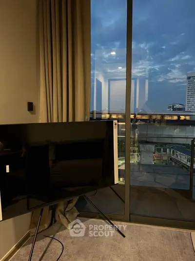Modern living room with large window and city view at dusk