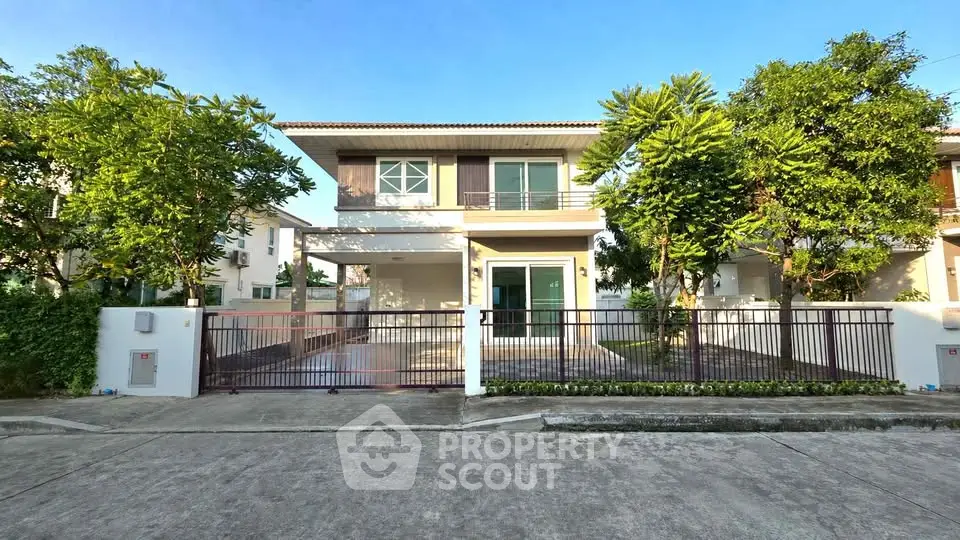 Charming two-story house with lush greenery and spacious driveway in a serene neighborhood.