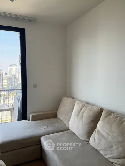 Cozy living room with plush sofa and city view from balcony