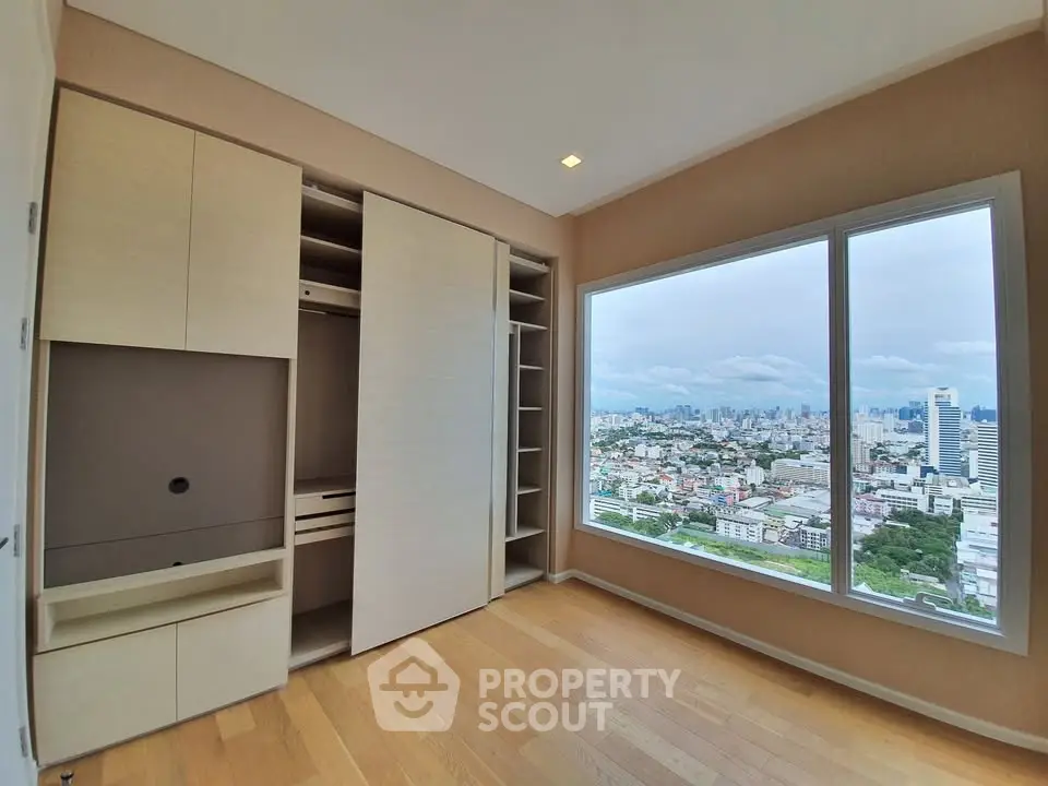 Spacious bedroom with panoramic city view and built-in wardrobe