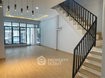 Spacious modern living room with wooden flooring and stylish staircase