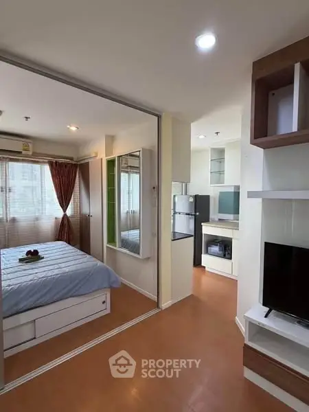 Modern apartment interior with cozy bedroom and open living area, featuring stylish decor and ample natural light.