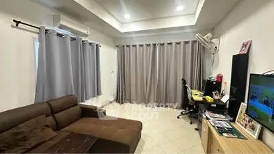 Spacious living room with modern decor, featuring a cozy sofa, entertainment center, and work desk.
