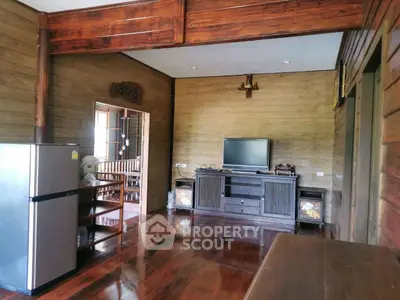 Charming rustic living room with wooden walls and modern amenities, perfect for cozy family gatherings.