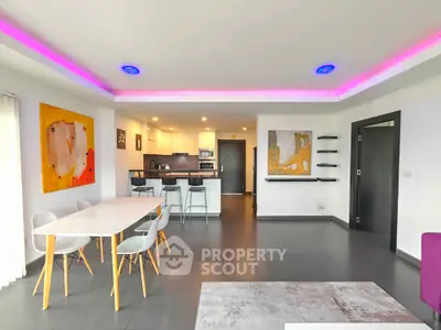 Modern open-plan living room with stylish kitchen and vibrant lighting