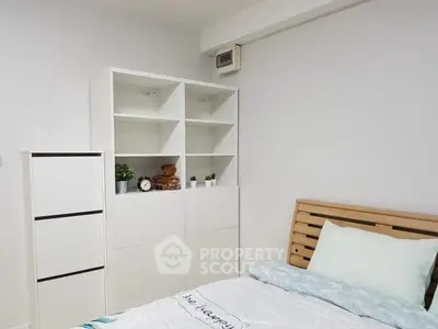 Cozy bedroom with modern shelving and wooden bed frame, perfect for a serene retreat.