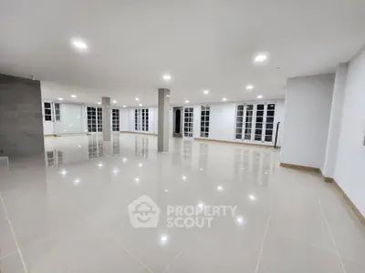 Spacious open-plan interior with modern tile flooring and ample natural light, perfect for versatile use.