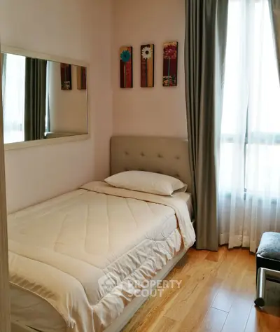 Cozy bedroom with soft lighting, wooden flooring, and elegant decor for a serene living experience.