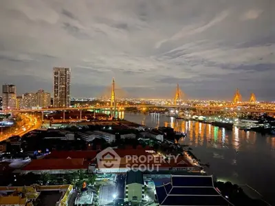 Stunning night view of city skyline with illuminated bridge and river, perfect for urban living enthusiasts.