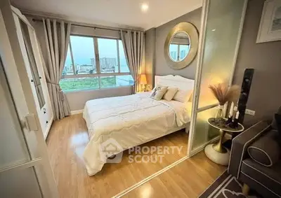 Cozy bedroom with large window offering city views, elegant decor, and wooden flooring.
