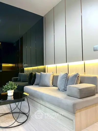 Modern living room with sleek design, featuring a stylish sofa and elegant lighting.