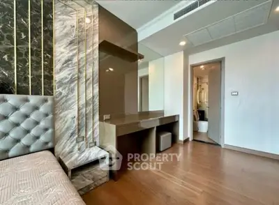 Luxurious bedroom with elegant decor and ensuite bathroom in modern apartment.