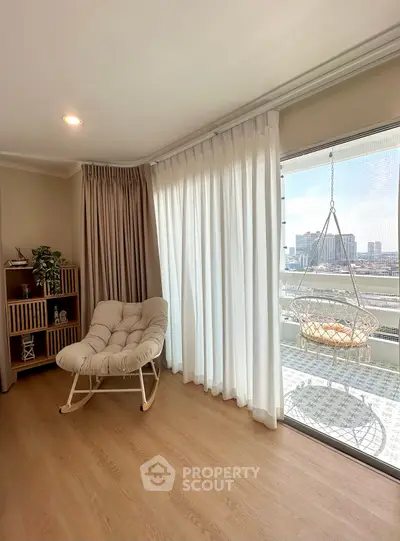 Stylish living room with cozy rocking chair and balcony view in modern apartment.