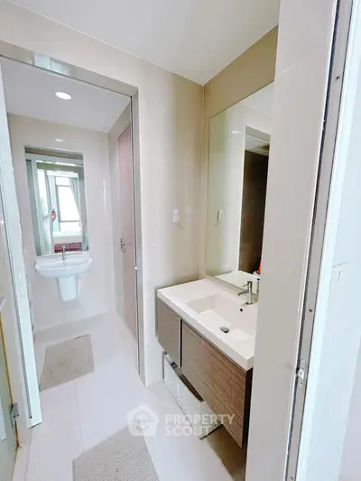 Modern bathroom with sleek vanity and large mirror in contemporary apartment.