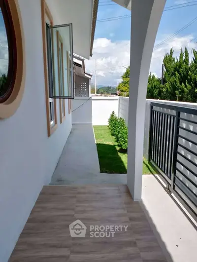 Charming balcony with garden view and modern railing in a serene neighborhood.