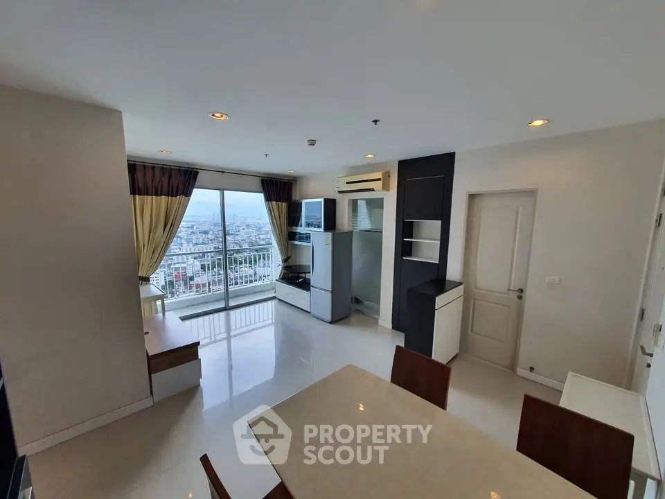 Spacious living room with city view and modern furnishings in high-rise apartment.
