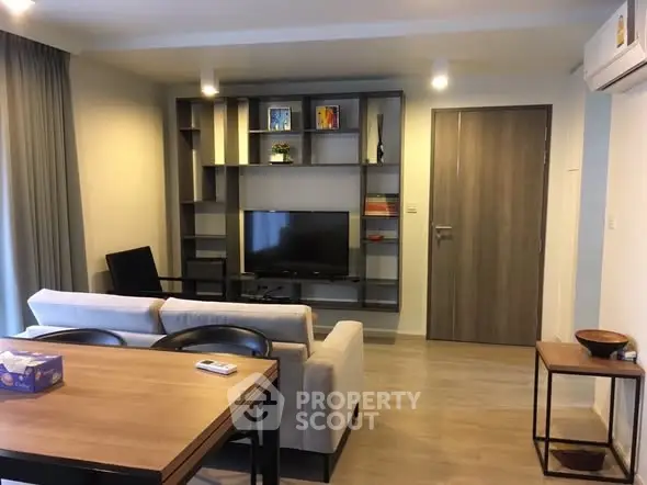Modern living room with stylish shelving and cozy seating area in a contemporary apartment.