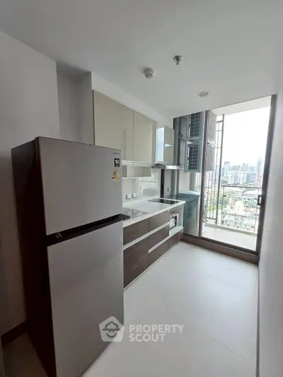 Modern kitchen with sleek cabinetry and city view from large window