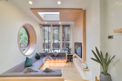 Modern sunken living room with circular window and stylish decor