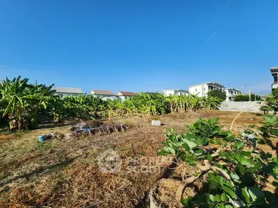 Spacious land plot with lush greenery and clear blue sky, ideal for development.