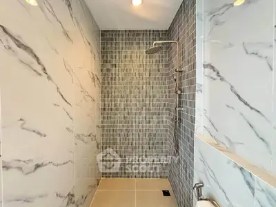 Luxurious modern bathroom with elegant marble tiles and sleek shower design.