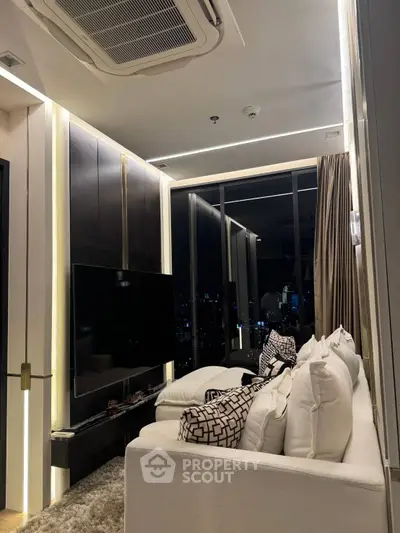 Luxurious modern living room with city view, featuring plush white sofa and large TV, perfect for relaxation.