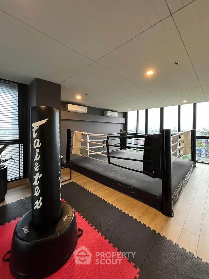 Modern gym with boxing ring and panoramic windows in luxury apartment building