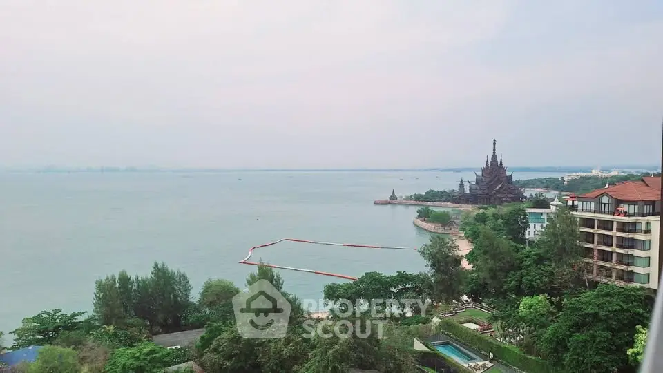 Stunning ocean view from high-rise balcony overlooking serene coastline and lush greenery.