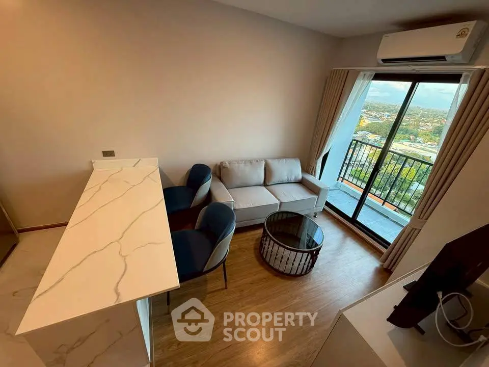 Modern living room with balcony and scenic view, featuring sleek furniture and air conditioning.