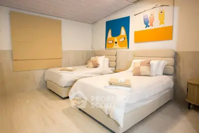 Charming bedroom with twin beds and playful artwork, perfect for a cozy retreat.