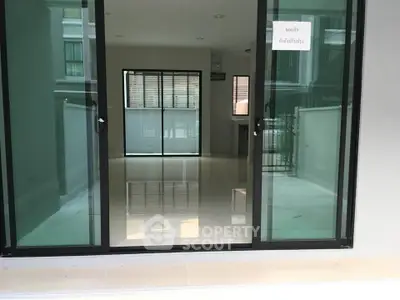 Spacious modern interior with large glass doors and sleek flooring, ideal for contemporary living.