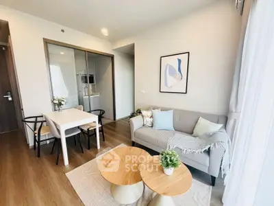 Modern living room with cozy decor and natural light in a stylish apartment.