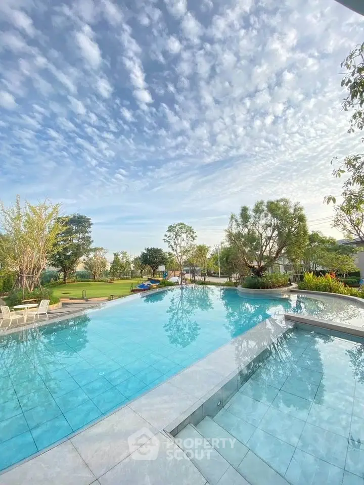Luxurious outdoor pool with stunning sky view in a serene residential setting.