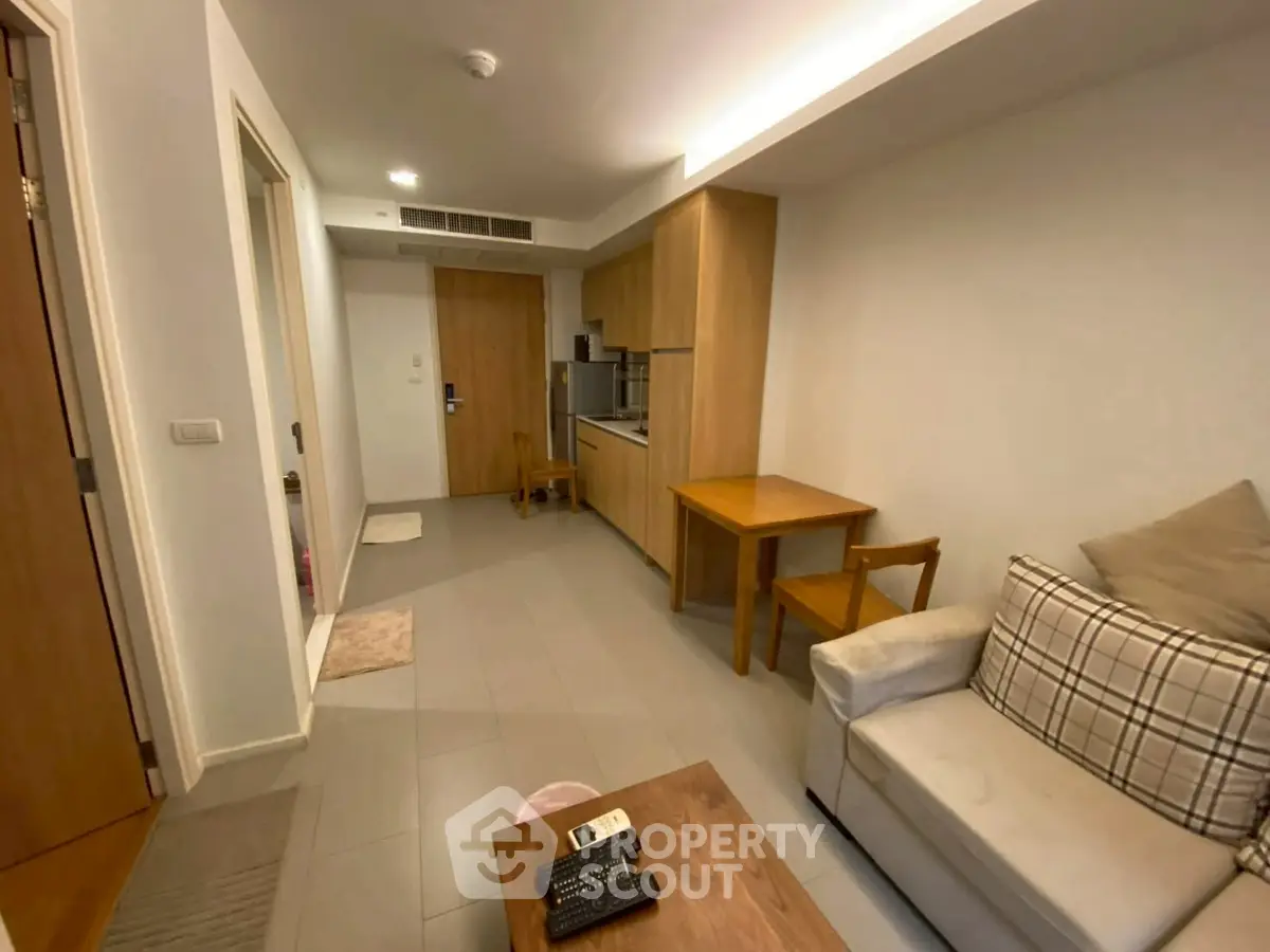 Cozy living room with modern kitchenette and comfortable seating in a stylish apartment.