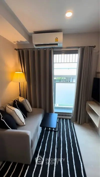 Cozy living room with modern decor and balcony access in stylish apartment.