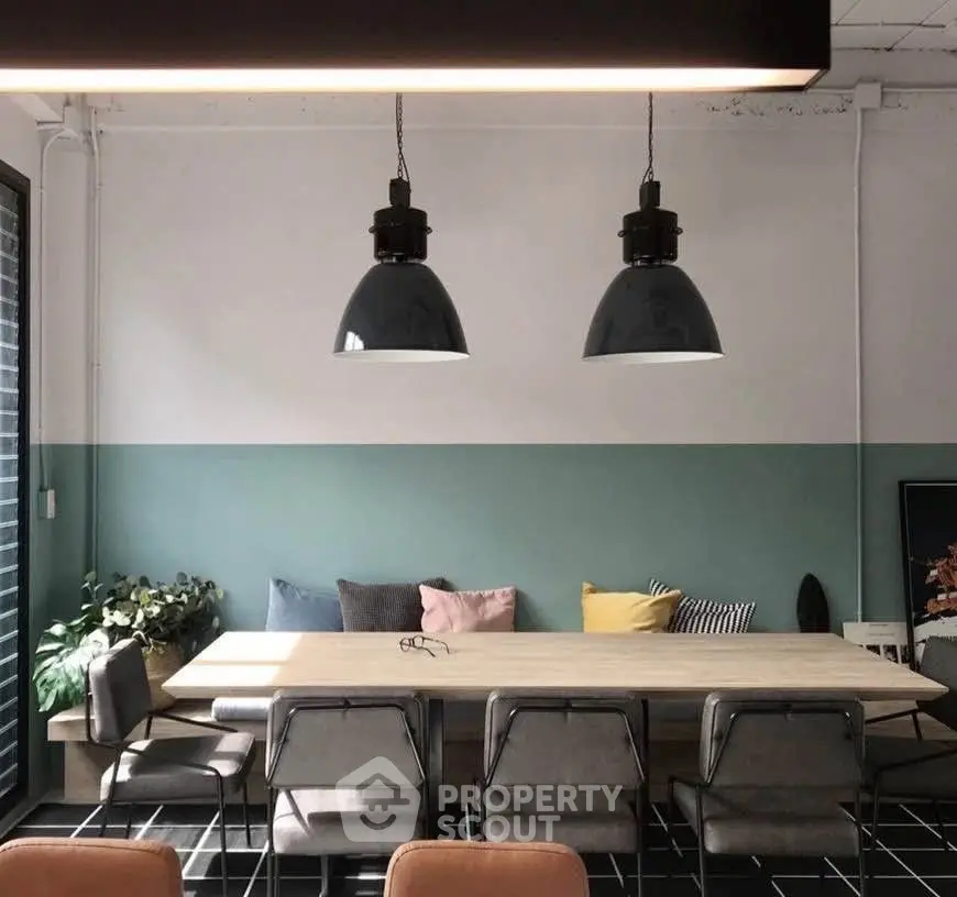 Stylish dining area with modern lighting and colorful cushions, perfect for contemporary living.