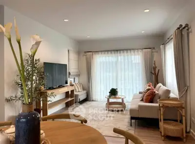 Charming living room with cozy seating, large TV, and elegant decor, perfect for relaxation and entertainment.
